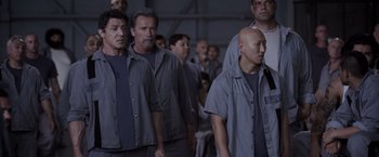 Movie still from “Escape Plan” (2013), directed by Mikael Håfström – A group of men standing next to each other in a room; Wide shot, Low angle
