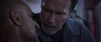 Movie still from “Escape Plan” (2013), directed by Mikael Håfström – An older man is looking at a younger man's face; Close Up shot, Low angle