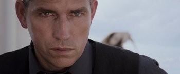 Movie still from “Escape Plan” (2013), directed by Mikael Håfström – A person wearing a suit and tie; Close Up shot, Low angle