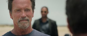 Movie still from “Escape Plan” (2013), directed by Mikael Håfström – A person with a man in the background; Close Up shot, Low angle