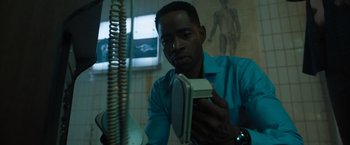 Movie still from “Escape Room: Tournament of Champions” (2021), directed by Adam Robitel – A man in a blue shirt is looking at his phone; Close Up shot, Low angle