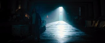 Movie still from “Escape Room: Tournament of Champions” (2021), directed by Adam Robitel – A person walking down a street in the light of an open door; Wide shot, Low angle