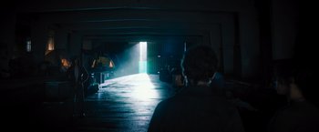 Movie still from “Escape Room: Tournament of Champions” (2021), directed by Adam Robitel – A man standing in a dark room with a light coming from the ceiling; Wide shot, Over the shoulder angle
