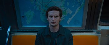 Movie still from “Escape Room: Tournament of Champions” (2021), directed by Adam Robitel – A man in a black jacket sitting in front of a map; Close Up shot, High angle