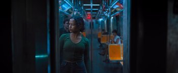 Movie still from “Escape Room: Tournament of Champions” (2021), directed by Adam Robitel – A woman standing on a subway train next to other passengers; Medium shot, Low angle