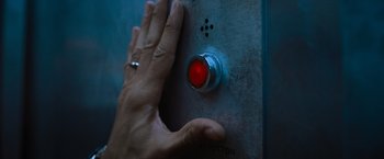 Movie still from “Escape Room: Tournament of Champions” (2021), directed by Adam Robitel – A person touching a red button on a wall; Extreme Close Up shot, High angle