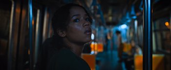 Movie still from “Escape Room: Tournament of Champions” (2021), directed by Adam Robitel – A woman is standing on a train looking up; Close Up shot, Low angle