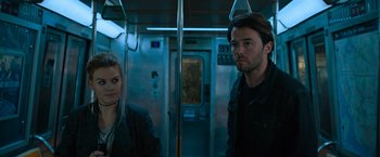 Movie still from “Escape Room: Tournament of Champions” (2021), directed by Adam Robitel – A man and a woman are standing on a train; Medium shot, Low angle