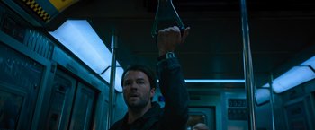 Movie still from “Escape Room: Tournament of Champions” (2021), directed by Adam Robitel – A man holding up an object on top of a train; Medium shot, Low angle