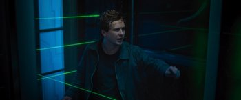 Movie still from “Escape Room: Tournament of Champions” (2021), directed by Adam Robitel – A young man in a dark room with green laser lights; Medium shot, Low angle