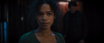 Movie still from “Escape Room: Tournament of Champions” (2021), directed by Adam Robitel – A young girl with curly black hair standing in a dark room; Close Up shot, Over the shoulder angle