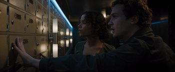 Movie still from “Escape Room: Tournament of Champions” (2021), directed by Adam Robitel – A man and a woman are looking at a wall; Medium shot, Low angle
