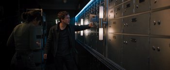 Movie still from “Escape Room: Tournament of Champions” (2021), directed by Adam Robitel – A man is looking at a row of lockers in a dark room; Medium shot, Low angle