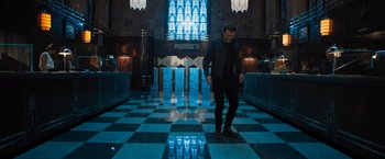 Movie still from “Escape Room: Tournament of Champions” (2021), directed by Adam Robitel – A man standing on a tiled floor in front of a window; Wide shot, Low angle