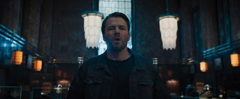 Movie still from “Escape Room: Tournament of Champions” (2021), directed by Adam Robitel – A man standing in front of a window with lights; Medium shot, Low angle