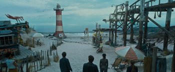 Movie still from “Escape Room: Tournament of Champions” (2021), directed by Adam Robitel – Three people standing on the beach near a lighthouse; Extreme Wide shot, High angle