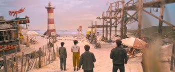 Movie still from “Escape Room: Tournament of Champions” (2021), directed by Adam Robitel – A group of people standing on top of a sandy beach; Wide shot, High angle