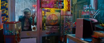 Movie still from “Escape Room: Tournament of Champions” (2021), directed by Adam Robitel – A lottery machine in a store with a lot of prizes on display; Medium shot, Low angle