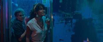 Movie still from “Escape Room: Tournament of Champions” (2021), directed by Adam Robitel – A woman standing next to a glass door; Medium shot, Low angle