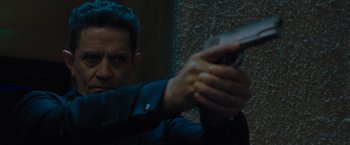 Movie still from “Escape Room: Tournament of Champions” (2021), directed by Adam Robitel – A person holding a gun in a room; Close Up shot, Over the shoulder angle