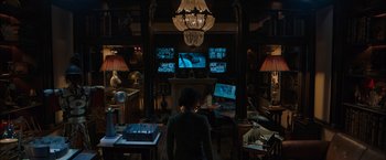 Movie still from “Escape Room: Tournament of Champions” (2021), directed by Adam Robitel – A woman standing in front of a television set; Wide shot, Over the shoulder angle
