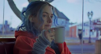 Movie still from “Eternal Sunshine of the Spotless Mind” (2004), directed by Michel Gondry – A woman with blue hair holding a cup of coffee; Close Up shot, Over the shoulder angle