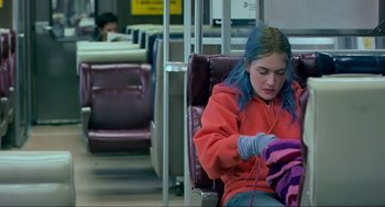 Movie still from “Eternal Sunshine of the Spotless Mind” (2004), directed by Michel Gondry – A woman sitting on a chair on a train; Medium shot, High angle