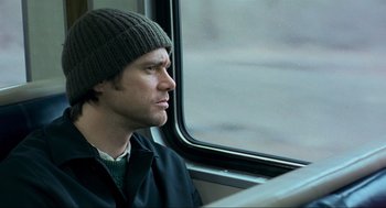 Movie still from “Eternal Sunshine of the Spotless Mind” (2004), directed by Michel Gondry – A man sitting on a train looking out the window; Close Up shot, Over the shoulder angle