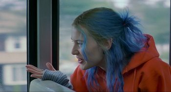 Movie still from “Eternal Sunshine of the Spotless Mind” (2004), directed by Michel Gondry – A woman with blue hair looking out of a window; Close Up shot, Over the shoulder angle