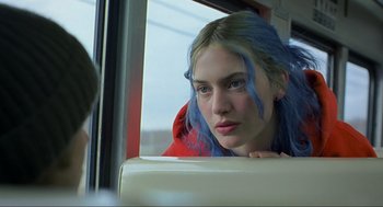 Movie still from “Eternal Sunshine of the Spotless Mind” (2004), directed by Michel Gondry – A woman with blue hair sitting on a bus; Close Up shot, Over the shoulder angle
