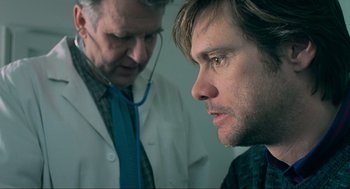 Movie still from “Eternal Sunshine of the Spotless Mind” (2004), directed by Michel Gondry – A man with a stethoscope around his neck and another man looking at him; Close Up shot, Over the shoulder angle