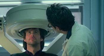 Movie still from “Eternal Sunshine of the Spotless Mind” (2004), directed by Michel Gondry – A man sitting in front of another man in a dentist's chair; Close Up shot, Over the shoulder angle