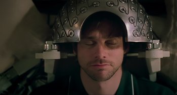 Movie still from “Eternal Sunshine of the Spotless Mind” (2004), directed by Michel Gondry – A man with a metal helmet on top of his head; Close Up shot, Overhead angle