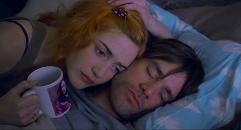 Movie still from “Eternal Sunshine of the Spotless Mind” (2004), directed by Michel Gondry – A man and a woman laying in a bed with a cup; Close Up shot, Overhead angle