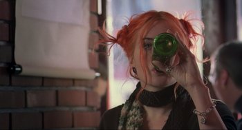 Movie still from “Eternal Sunshine of the Spotless Mind” (2004), directed by Michel Gondry – A woman with red hair holding up a green bottle; Close Up shot, Low angle