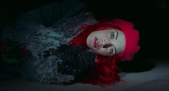 Movie still from “Eternal Sunshine of the Spotless Mind” (2004), directed by Michel Gondry – A woman with red hair and a red hat laying on the ground with a dog; Close Up shot, Overhead angle