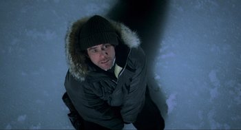 Movie still from “Eternal Sunshine of the Spotless Mind” (2004), directed by Michel Gondry – A man wearing a winter coat and a hat; Medium shot, Overhead angle