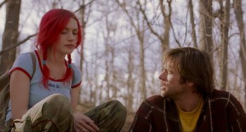 Movie still from “Eternal Sunshine of the Spotless Mind” (2004), directed by Michel Gondry – A man and a woman sitting on the ground in the woods; Medium shot, Over the shoulder angle