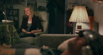 Movie still from “Eternal Sunshine of the Spotless Mind” (2004), directed by Michel Gondry – A woman sitting on a couch in a living room; Medium shot, Over the shoulder angle