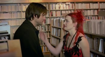 Movie still from “Eternal Sunshine of the Spotless Mind” (2004), directed by Michel Gondry – A man and a woman in front of bookshelves; Medium shot, Over the shoulder angle