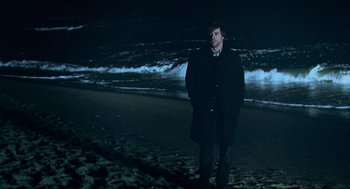 Movie still from “Eternal Sunshine of the Spotless Mind” (2004), directed by Michel Gondry – A man standing on the beach at night; Wide shot, Over the shoulder angle