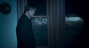 Movie still from “Eternal Sunshine of the Spotless Mind” (2004), directed by Michel Gondry – A man standing in front of a window at night; Medium shot, Over the shoulder angle