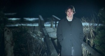 Movie still from “Eternal Sunshine of the Spotless Mind” (2004), directed by Michel Gondry – A man standing in front of a wooden fence; Medium shot, Low angle