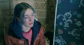Movie still from “Eternal Sunshine of the Spotless Mind” (2004), directed by Michel Gondry – A woman with blue hair sitting in a chair; Close Up shot, High angle