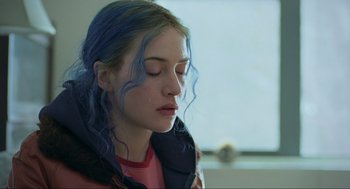 Movie still from “Eternal Sunshine of the Spotless Mind” (2004), directed by Michel Gondry – A woman with blue hair is looking down; Close Up shot, Over the shoulder angle