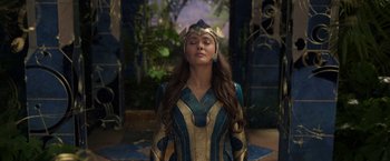 Movie still from “Eternals” (2021), directed by Chloé Zhao – A woman in a blue and gold costume with her eyes closed; Medium shot, High angle
