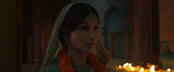 Movie still from “Eternals” (2021), directed by Chloé Zhao – A woman wearing a head scarf and a flower garland; Close Up shot, Over the shoulder angle