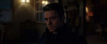 Movie still from “Eternals” (2021), directed by Chloé Zhao – A person wearing a black jacket; Close Up shot, Over the shoulder angle