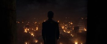 Movie still from “Eternals” (2021), directed by Chloé Zhao – A man standing in front of a burning city at night; Extreme Wide shot, High angle
