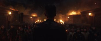 Movie still from “Eternals” (2021), directed by Chloé Zhao – A man is standing in front of a crowd of people; Medium shot, Low angle